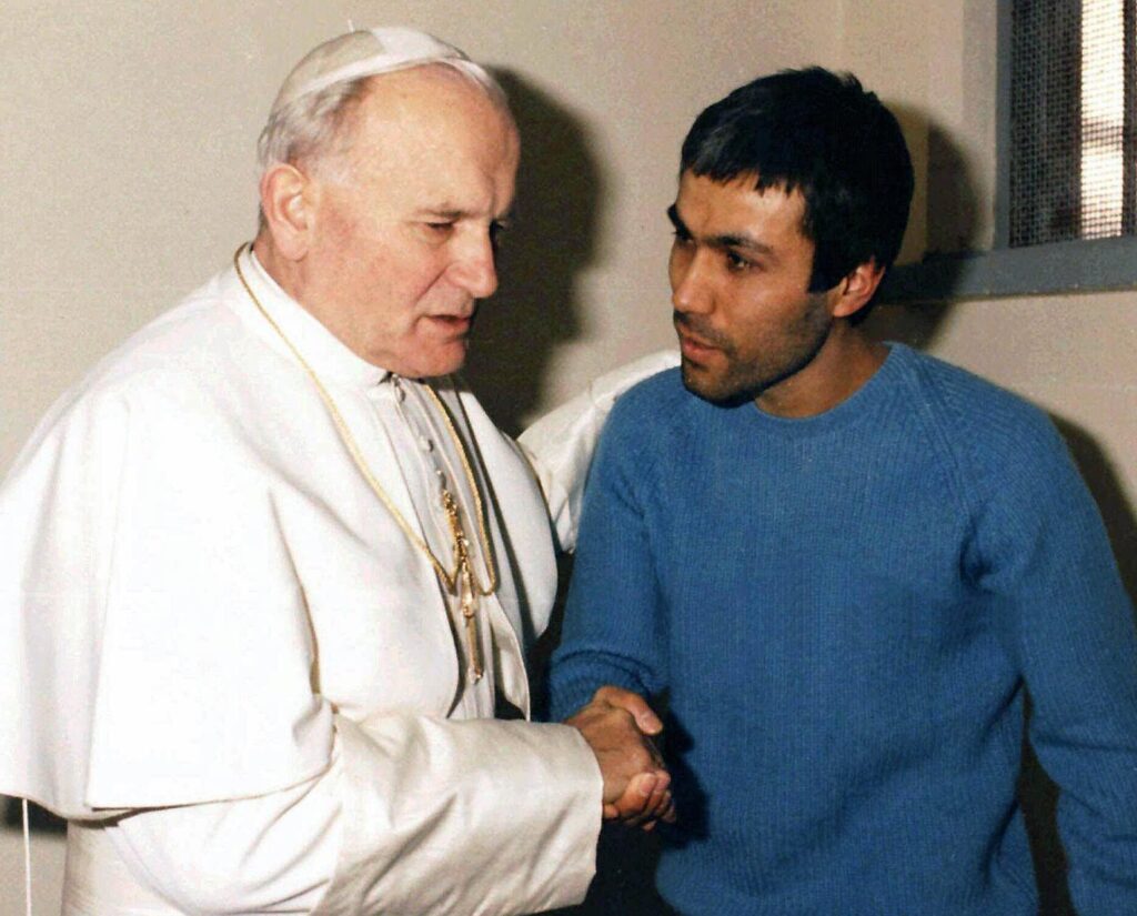 Pope John Paul II shaking hands with the man that shot at him 4 times two years prior