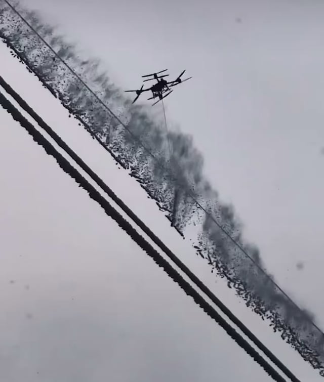 Using a drone to clear ice from power lines