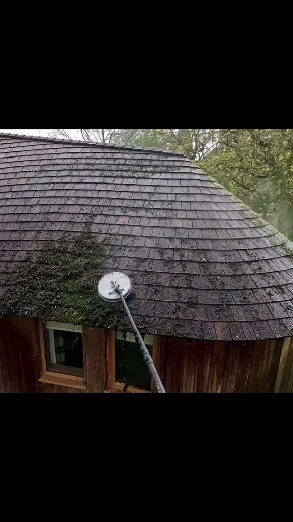 Guy shows the process of cleaning a roof