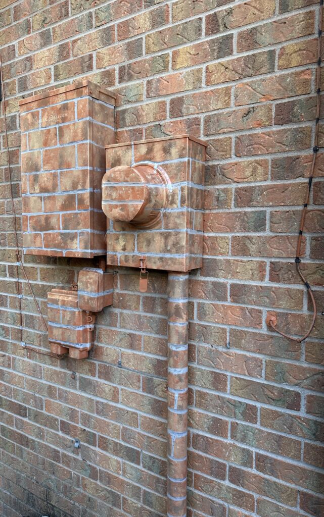 Painted electrical boxes to match bricks.