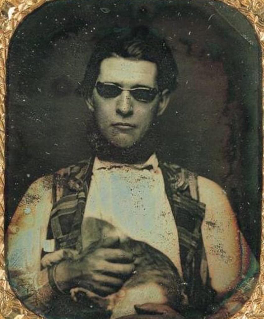 Daguerreotype of a man wearing tinted glasses and holding a cat, c. 1850. These photos show the oldest generation of people to be photographed.