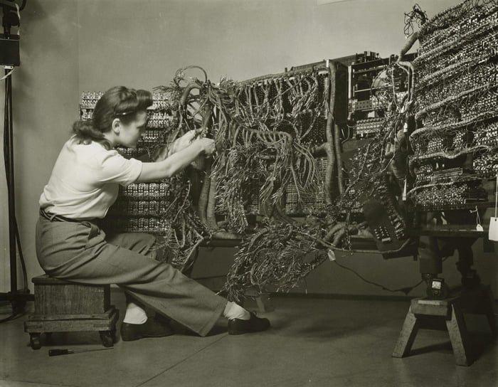 A photo of an engineer wiring an early IBM computer, 1958.